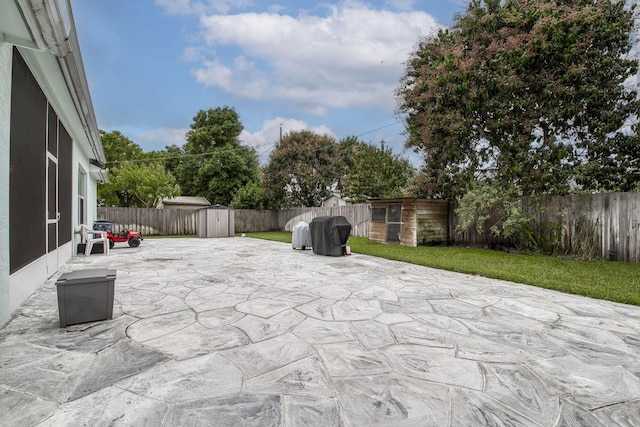 view of patio / terrace with a shed, a fenced backyard, and an outbuilding