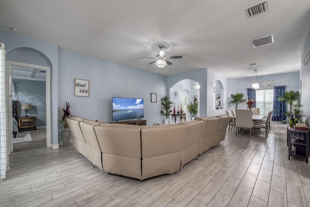 living room featuring ceiling fan, visible vents, and wood finish floors