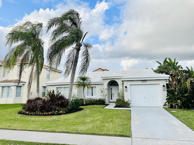 view of front facade with concrete driveway, a front lawn, an attached garage, and stucco siding