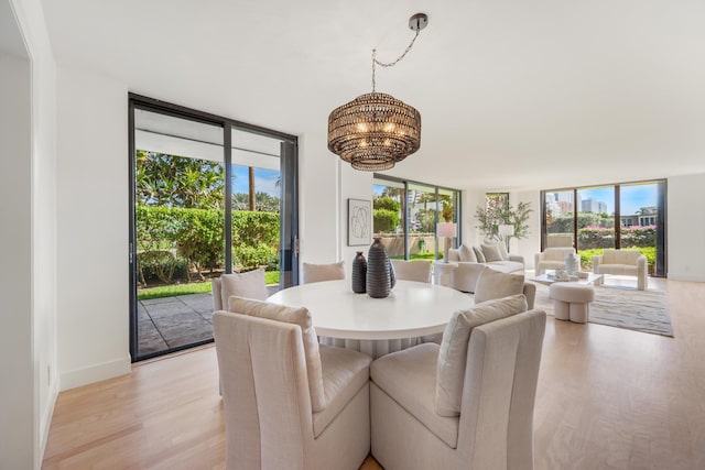 dining room with a chandelier, plenty of natural light, and light wood-style floors