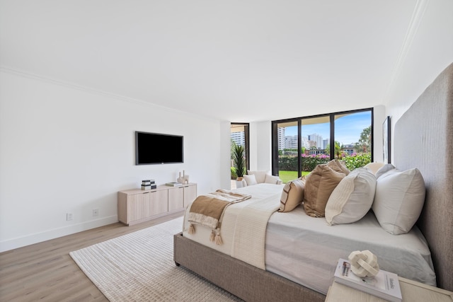 bedroom featuring ornamental molding, baseboards, and wood finished floors