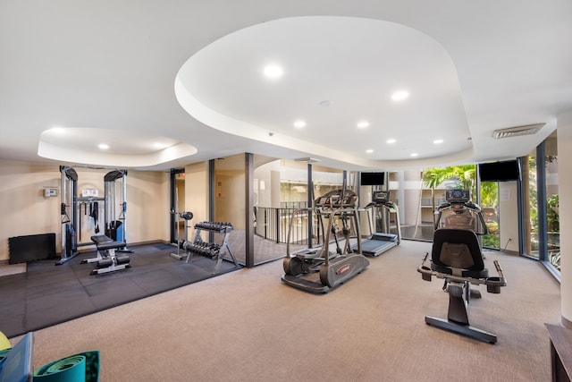 gym with recessed lighting, a raised ceiling, visible vents, and floor to ceiling windows