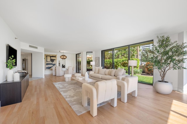 living room with light wood-style flooring and visible vents