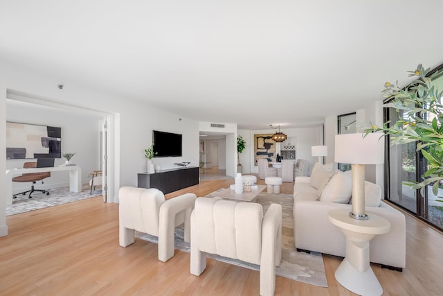 living room featuring light wood-style floors and visible vents