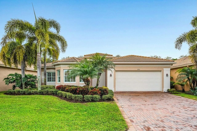 mediterranean / spanish home featuring a garage, a front yard, decorative driveway, and stucco siding