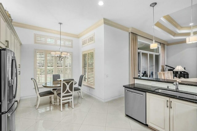 kitchen with hanging light fixtures, crown molding, appliances with stainless steel finishes, and a sink