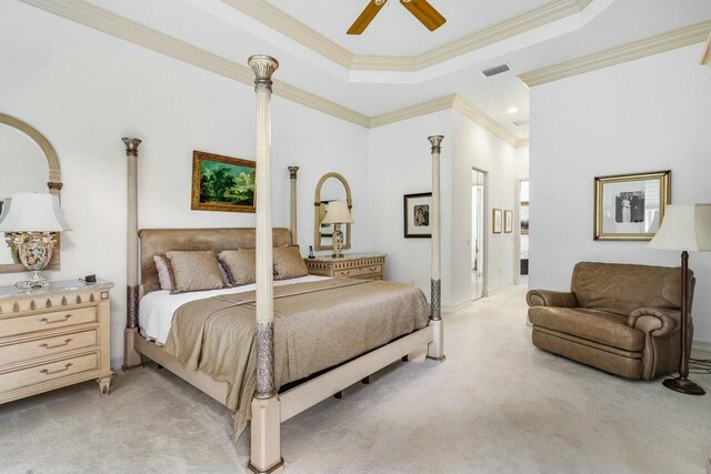 bedroom with light carpet, visible vents, a ceiling fan, ornamental molding, and a tray ceiling