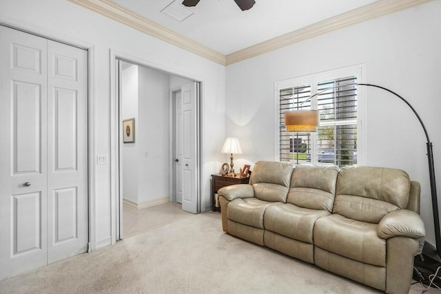 living area with ceiling fan, light colored carpet, visible vents, baseboards, and ornamental molding