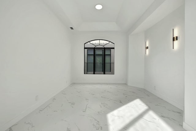 unfurnished room with marble finish floor, a tray ceiling, visible vents, and baseboards