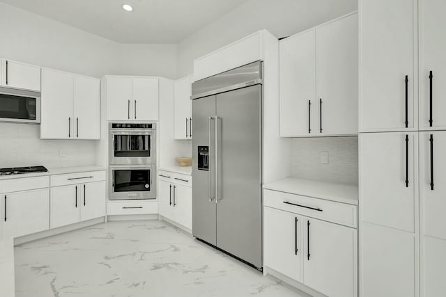 kitchen with white cabinets, marble finish floor, stainless steel appliances, and light countertops