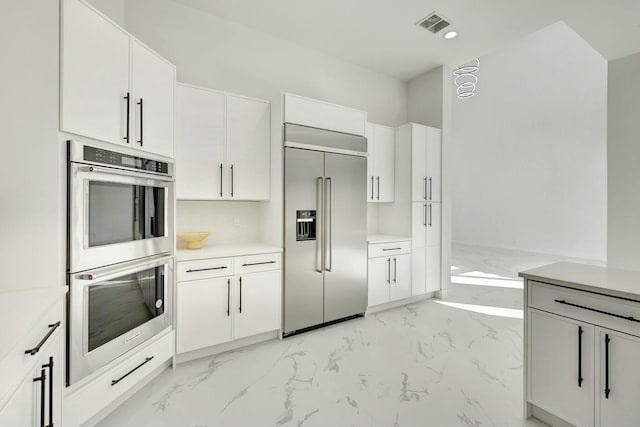 kitchen with visible vents, appliances with stainless steel finishes, white cabinets, and light countertops