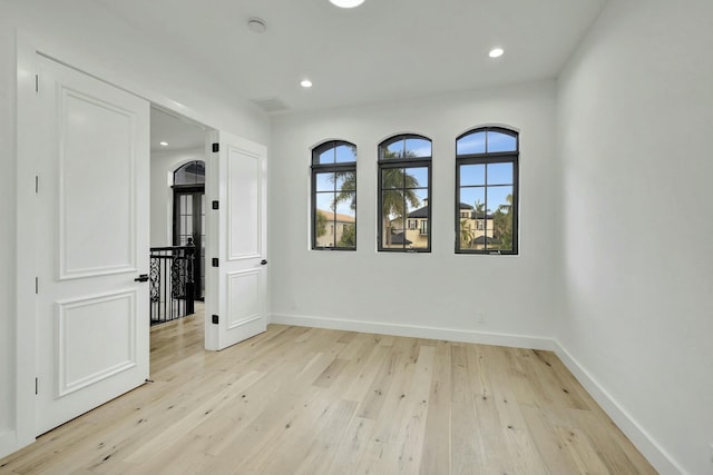 unfurnished room featuring light wood-style floors, recessed lighting, visible vents, and baseboards