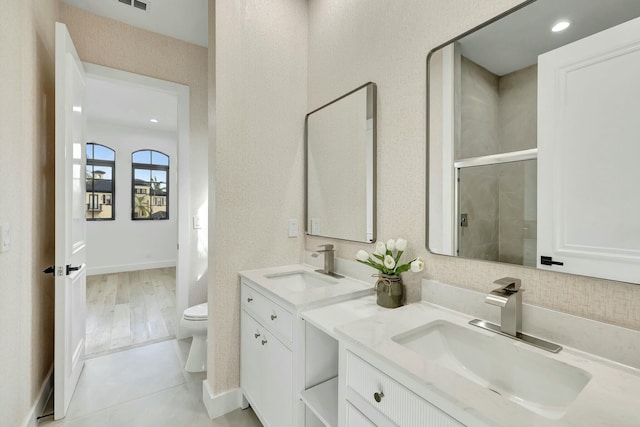 full bath featuring double vanity, toilet, a sink, and tile patterned floors