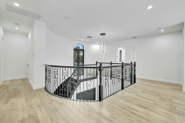 hall with recessed lighting, visible vents, baseboards, an upstairs landing, and light wood-type flooring