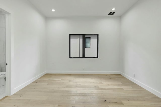 unfurnished room with recessed lighting, visible vents, light wood-style flooring, and baseboards