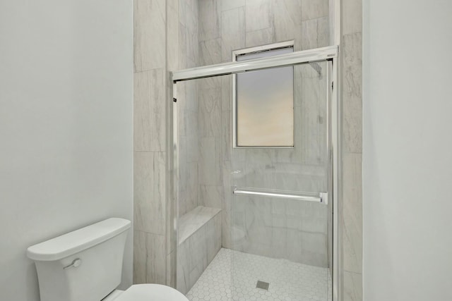 bathroom featuring a stall shower and toilet