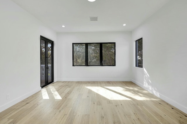 spare room with light wood-type flooring, a healthy amount of sunlight, baseboards, and recessed lighting