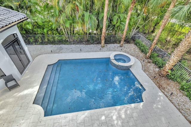 view of pool featuring a patio area, a pool with connected hot tub, and a fenced backyard