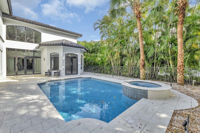 view of swimming pool with french doors, a patio area, fence, and a pool with connected hot tub