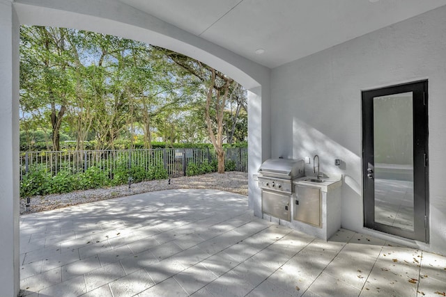 view of patio / terrace featuring a fenced backyard, a sink, and area for grilling