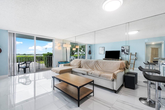 living room featuring baseboards, floor to ceiling windows, and a textured ceiling