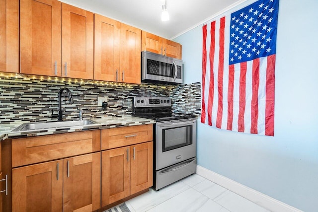 kitchen featuring tasteful backsplash, light countertops, appliances with stainless steel finishes, brown cabinetry, and a sink