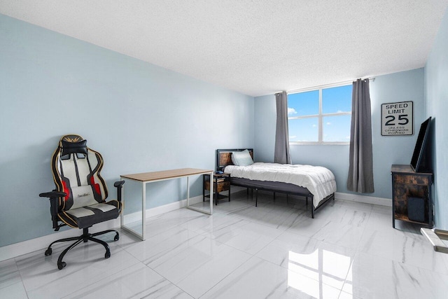 bedroom with marble finish floor, baseboards, and a textured ceiling