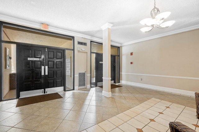 entryway featuring crown molding, light tile patterned flooring, and ornate columns