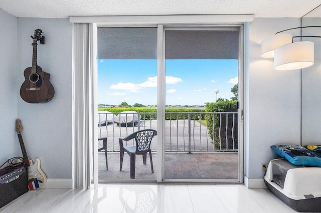 doorway with a wall of windows and baseboards