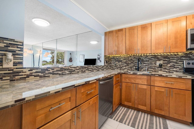 kitchen featuring stainless steel appliances, brown cabinetry, a sink, and decorative backsplash