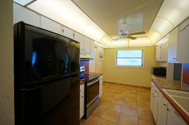 kitchen with stainless steel electric range, white cabinets, a raised ceiling, and freestanding refrigerator