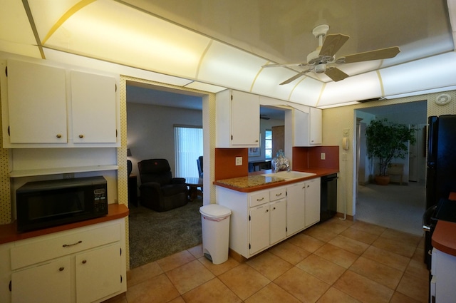 kitchen featuring white cabinetry, ceiling fan, a sink, light tile patterned flooring, and black appliances