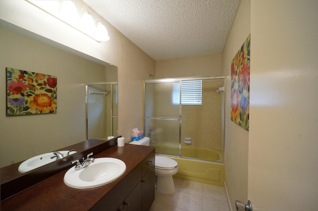 bathroom with a textured ceiling, tile patterned flooring, toilet, shower / bath combination with glass door, and vanity