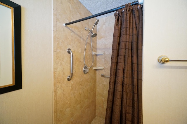 bathroom with a textured ceiling and a stall shower