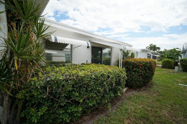 view of property exterior with a yard and stucco siding