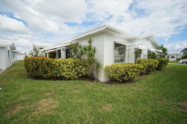 view of home's exterior featuring a lawn and stucco siding