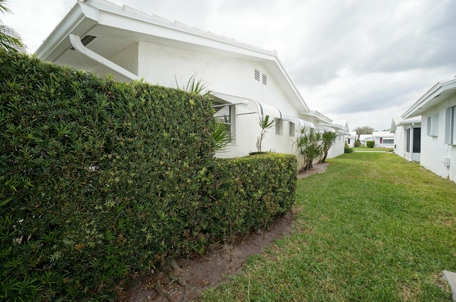 view of side of property featuring a yard and stucco siding