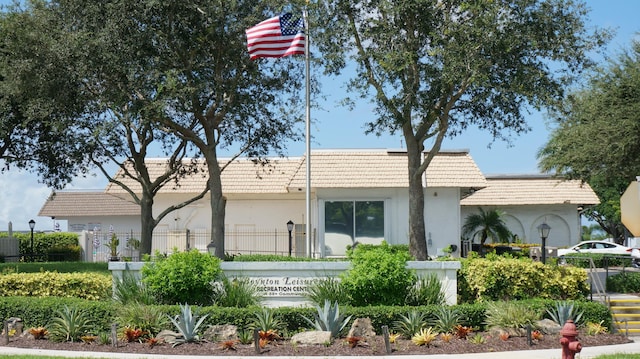 ranch-style house featuring a fenced front yard and stucco siding