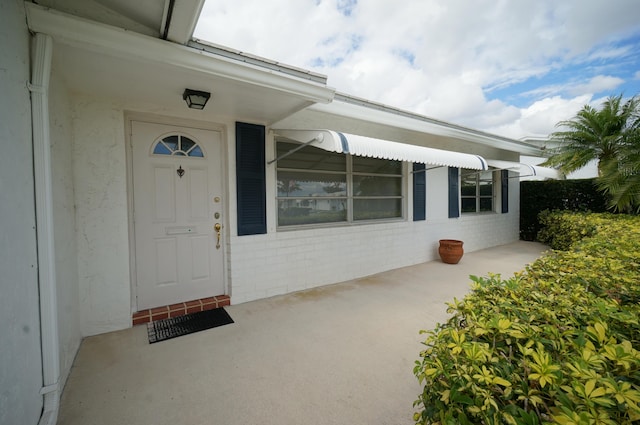 view of exterior entry with brick siding