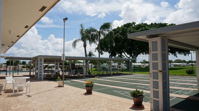 view of home's community with shuffleboard and fence