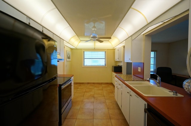 kitchen with white cabinetry, a raised ceiling, a sink, and freestanding refrigerator