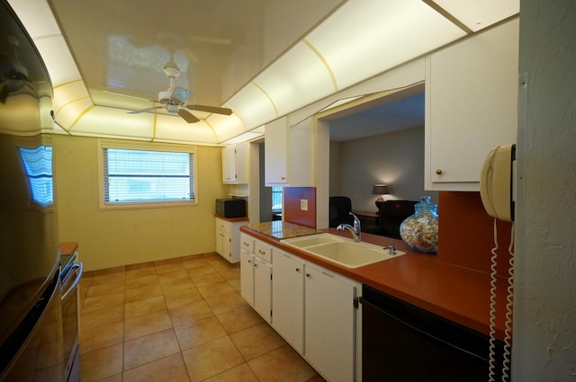 kitchen featuring ceiling fan, stove, a sink, white cabinets, and black dishwasher