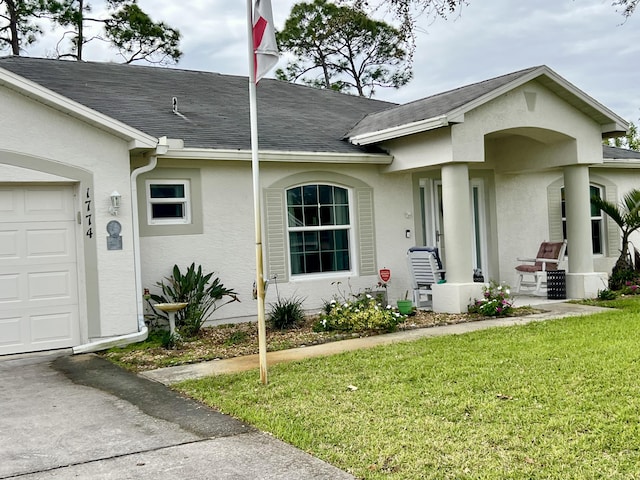 exterior space with an attached garage, a yard, roof with shingles, and stucco siding