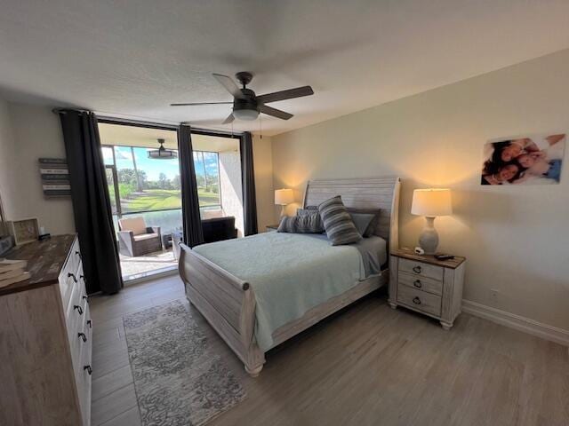 bedroom featuring floor to ceiling windows, ceiling fan, baseboards, and wood finished floors