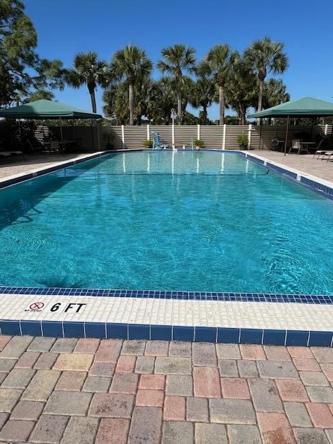 community pool with fence and a gazebo