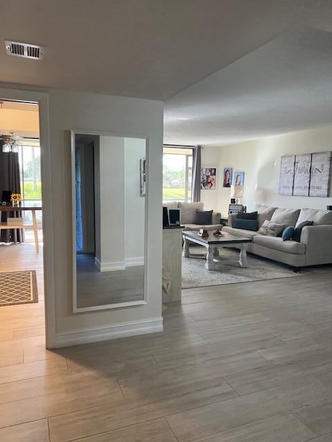 living area with plenty of natural light, wood tiled floor, and visible vents