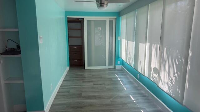 corridor with wood finished floors and baseboards