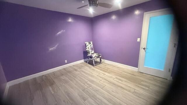 unfurnished room featuring a ceiling fan, baseboards, and wood finished floors