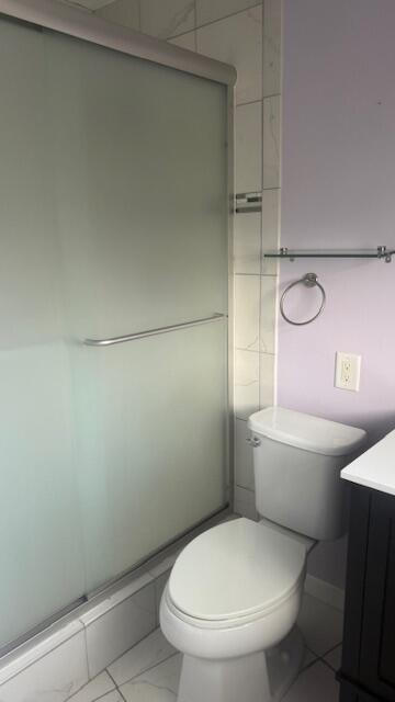 full bath with toilet, a shower stall, and vanity