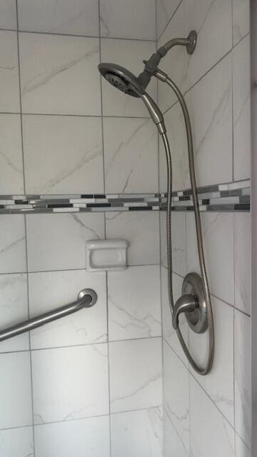 interior details featuring tiled shower